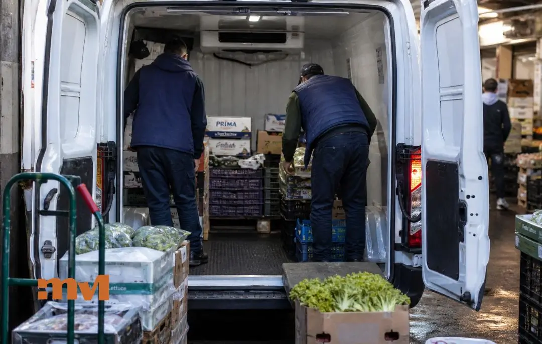 Mejor furgoneta para alimentación en 2026 guía para orientar tu compra - Personas cargando una furgoneta en un mercado, preparando para reparto